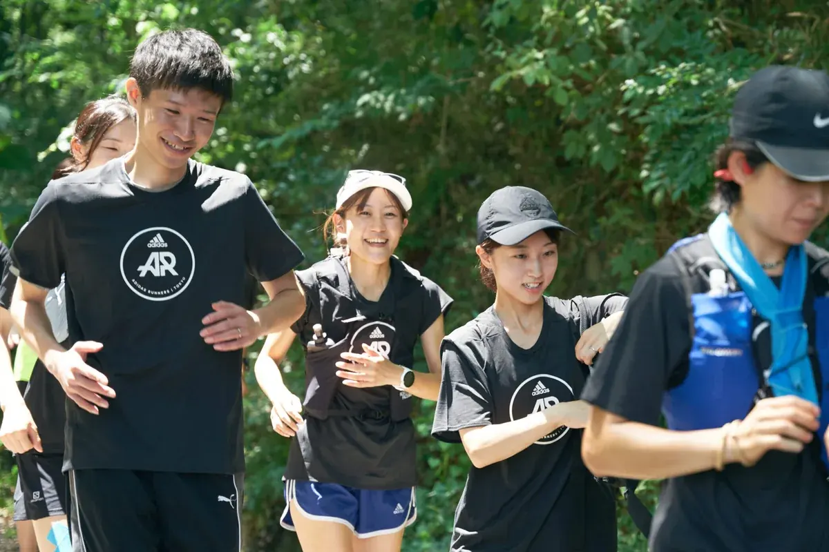 緑に囲まれた道を走るランニングの仲間